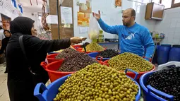 Warga membeli buah zaitun untuk persiapan menyambut datangnya bulan Ramadan di Ibu Kota Tripoli, Libya, 1 Mei 2019. Ramadan kali ini diperkirakan akan terasa berat bagi warga Tripoli karena bayang-bayang krisis dan pertempuran. (MAHMUD TURKIA/AFP)