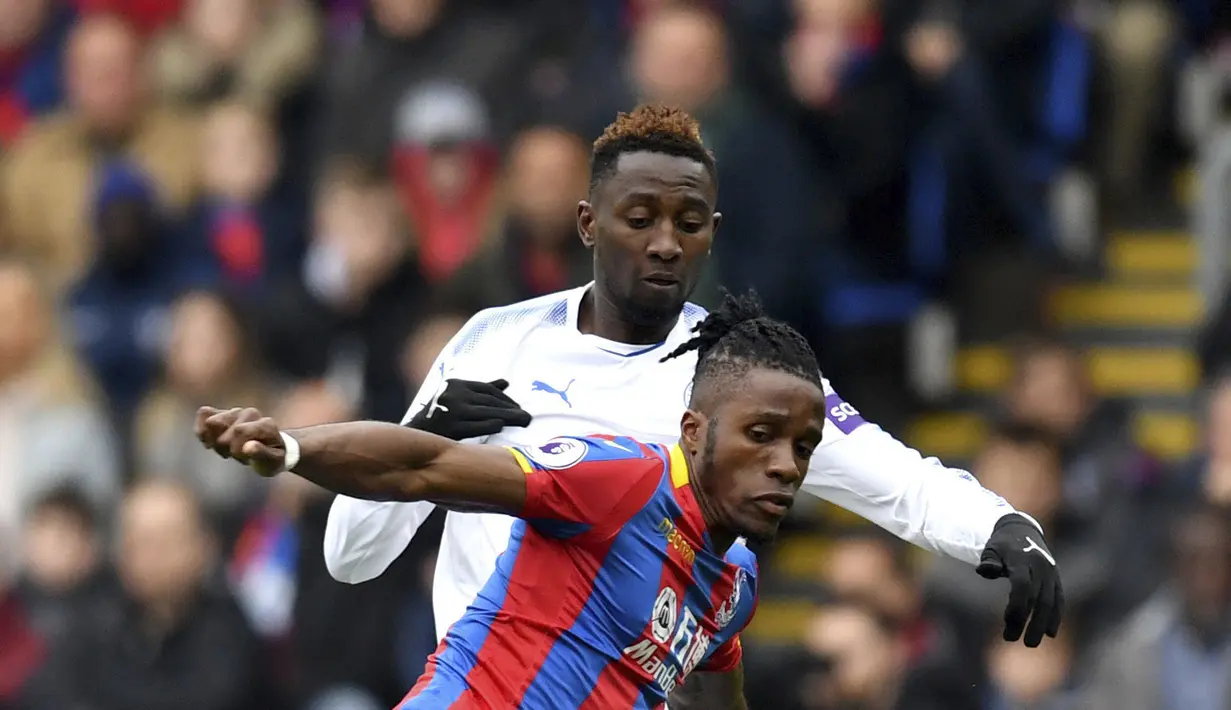 Pemain Crystal Palace, Wilfried Zaha (depan) mengecoh pemain Leicester City, Wilfred Ndidi pada lanjutan Premier League di Selhurst Park, London, (28/4/2018). Crystal Palace menang 5-0. (Dominic Lipinski/PA via AP)