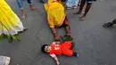 Seorang anak diletakan di jalan saat mengikuti festival keagamaan Chhat Puja di Kolkata, India (6/11). Ritual ini bertujuan untuk mencari berkah, meminta kesejahteraan, dan kemakmuran dari Dewa Matahari. (Reuters/Rupak De Chowdhuri)
