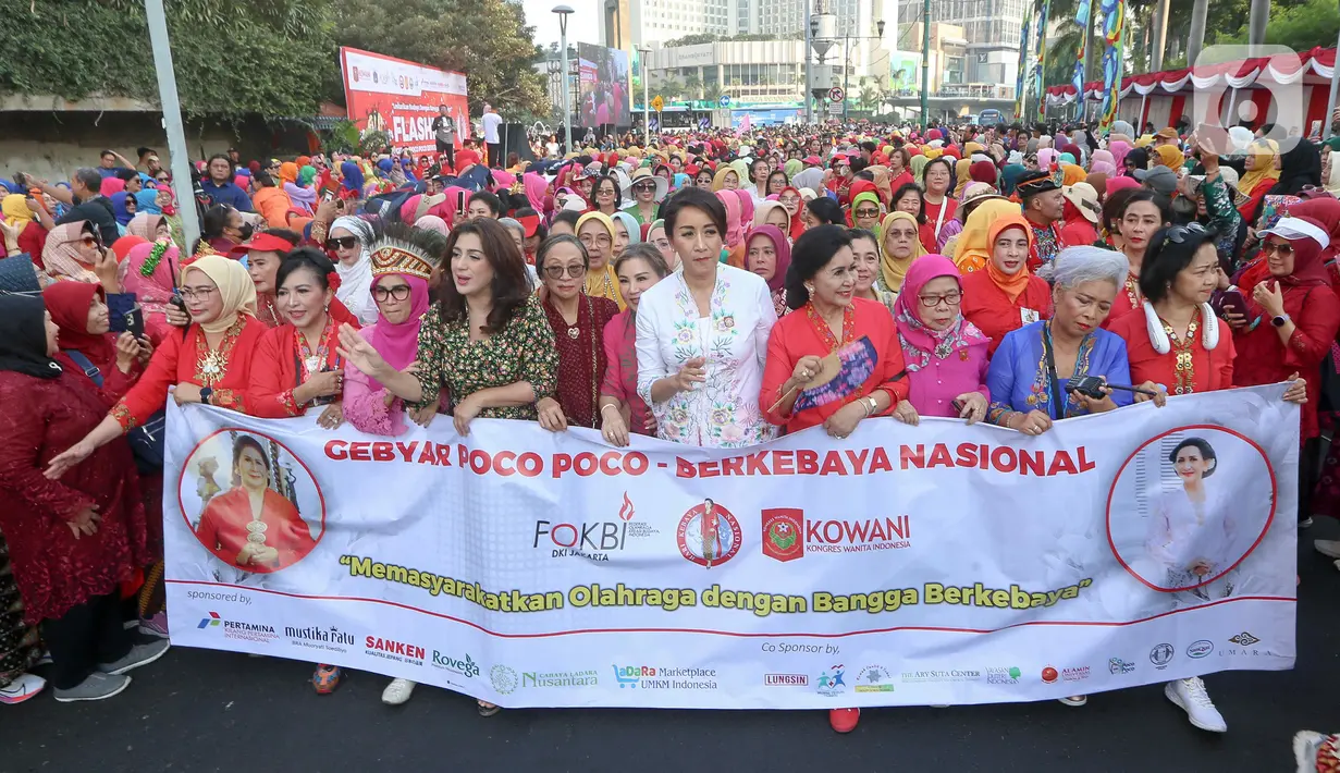 Para perempuan dari segala umur membentangkan spanduk saat acara Flashmob Poco-poco Berkebaya  di Bundaran HI, Jakarta, Minggu (14/7/2024). (Liputan6.com/Herman Zakharia)