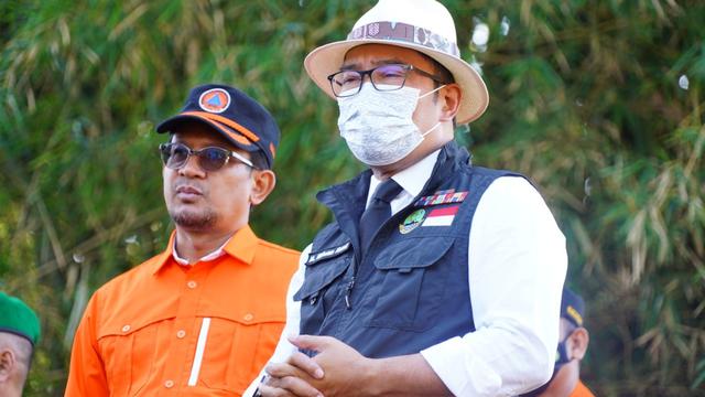 Gubernur Jabar Ridwan Kamil didampingi Wabup Garut Helmi Budiman memberikan keterangan kepada wartwan di lokasi terdampak banjir Kampung Cikarokrok, Desa Sukasenang, Kecamatan Banyuresmi. (Liputan6.com/Jayadi Supriadin)