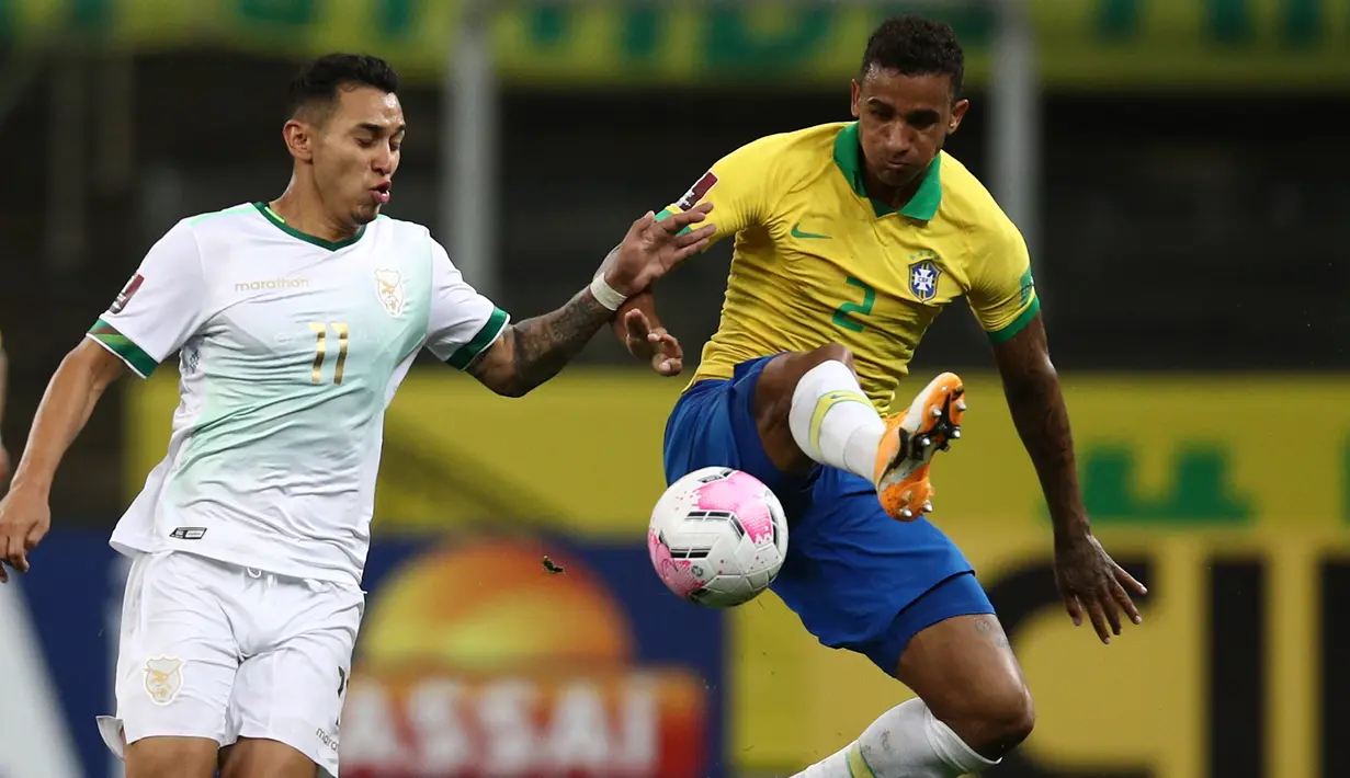 Bek Brasil, Danilo, berebut bola dengan pemain Bolivia pada laga kualifikasi Piala Dunia 2020 di Corinthians Arena, Sabtu (10/10/2020) pagi WIB. Brasil menang 5-0 atas Bolivia. (AFP/Buda Mendes/various sources)