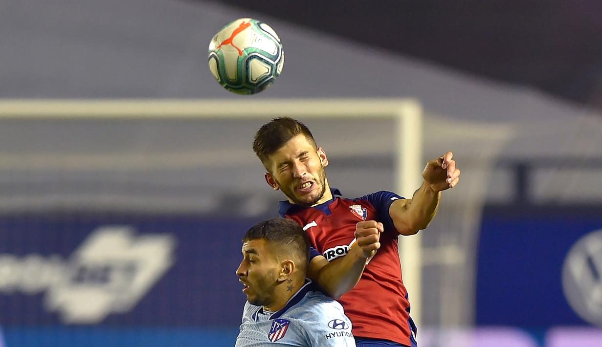 Penyerang Atletico Madrid, Angel Correa, berebut bola dengan bek Osasuna, David Garcia, pada laga lanjutan La Liga pekan ke-29 di Stadion El Sadar, Pamplona, Kamis (18/6/2020) dini hari WIB. Atletico menang telak 5-0 atas Osasuna. (AFP/Ander Gillenea)