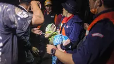 Tim penyelamat mengevakuasi balita di tengah banjir akibat hujan deras di Medan, Sumatera Utara (4/12/2020). Meluapnya air Sungai Sunggal yang menjadi pembatas antara Kabupaten Deli Serdang dengan Kota Medan, Sumatera Utara, menyebabkan ratusan rumah warga terendam banjir. (AFP/Albert Ivan Damanik)