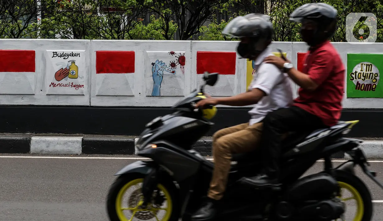 Warga melintasi mural sosialisasi bahaya COVID-19 di Jalan Sultan Iskandar Muda, Jakarta, Rabu (23/9/2020). PSBB pengetatan sepekan terakhir ini belum efektif menurunkan angka jumlah harian Covid-19 di DKI yang tercatat bertambah 1.122 kasus di ibu kota pada Selasa (22/9). (Liputan6.com/Johan Tallo)