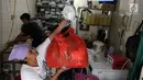 Pekerja menimbang pakaian di toko laundry di Jakarta, Rabu (20/6). Libur lebaran banyak jasa laundry kebanjiran order hingga 100 karena banyaknya para pembatu rumah tangga yang mudik lebaran. (Liputan6.com/Angga Yuniar)