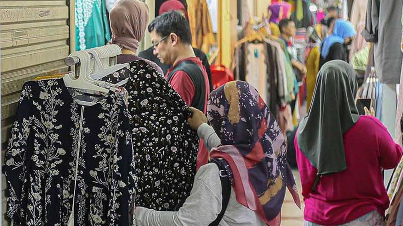 Sementara, ada pula pengunjung yang sibuk memilih pakaian di kios pedagang.