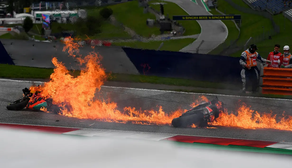 Kobaran api timbul usai tabrakan antara pembalap tim Aprilia Gresini, Lorenzo Savadori dengan Dani Pedrosa dari tim KTM Red Bull saat balapan memasuki lap ketiga. (Foto: AFP/Joe Klamar)