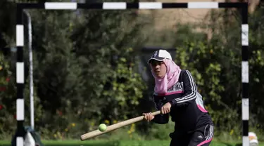 Seorang wanita Palestina memukul bola saat mengikuti sesi latihan bisbol di Khan Younis, Jalur Gaza, 19 Maret 2017. Sekelompok wanita muda muslim mencoba olahraga bisbol sebagai hiburan. (AP Photo/Khalil Hamra)