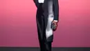 Mickalene Thomas mengenakan mantel bermotif hitam Dior Spring-Summer, kemeja katun putih, dan celana wol hitam. Dia juga memakai sepatu Dior. [Dior]