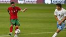 Gelandang Portugal, Bruno Fernandes (kiri) melepaskan tendangan yang berbuah gol keempat Portugal ke gawang Israel dalam laga uji coba menjelang Euro 2020 di Jose Alvalade Stadium, Lisbon, Rabu (9/6/2021). Portugal menang 4-0 atas Israel. (AP/Armando Franca)