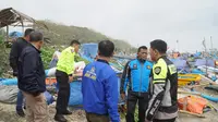 Kapolres Tasikmalaya AKBP Suhardi Heri bersama anggota lainnya tengah melakukan pengecekan setelah gelombang tinggi di wilayah pesisir pantai selatan Jawa pekan lalu. (Li[putan6.com/Jayadi Supriadin)