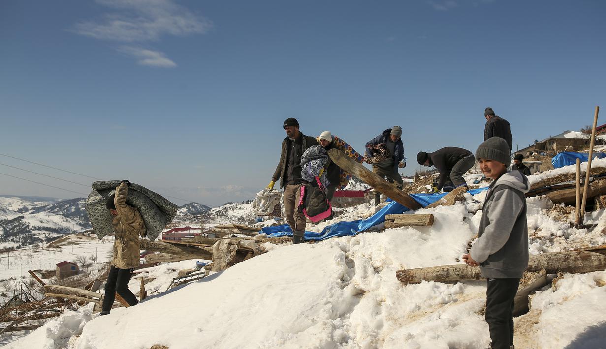 Penduduk desa berusaha mengeluarkan bahan alas tidur mereka dari rumah yang runtuh di desa Buyuknacar di Kahramanmaras, Turki, Rabu, 15 Februari 2023. Lebih dari 35.000 orang tewas di Turki akibat gempa minggu lalu, menjadikannya bencana paling mematikan sejak negara itu didirikan 100 tahun lalu. (AP Photo/Emrah Gurel)
