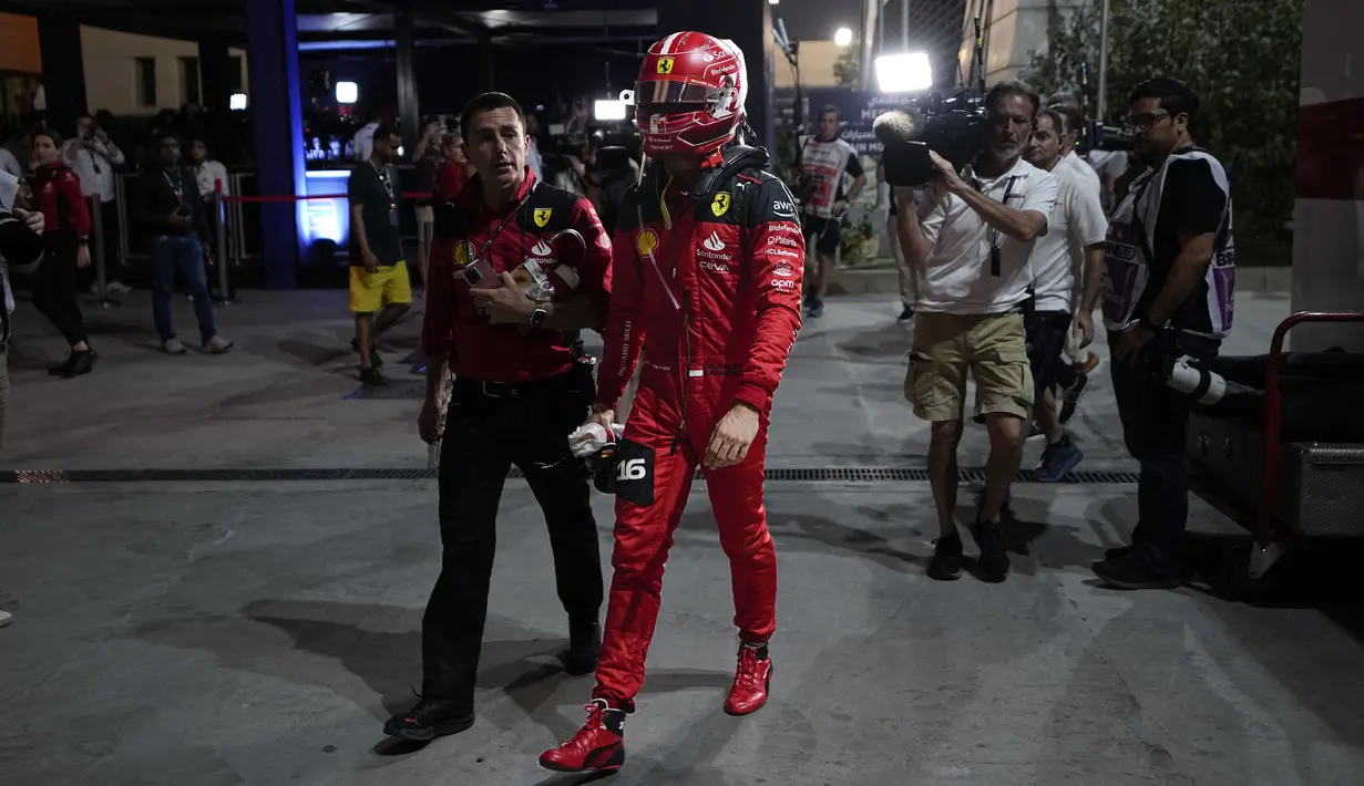 Pebalap Scuderia Ferrari, Charles Leclerc berjalan kembali menuju pit lane setelah mobilnya mengalami masalah mesin saat Formula 1 GP Bahrain 2023 yang berlangsung di Sirkuit Internasional Bahrin, Sakhir, Minggu (05/03/2023) WIB. (AP Photo/Ariel Schalit)
