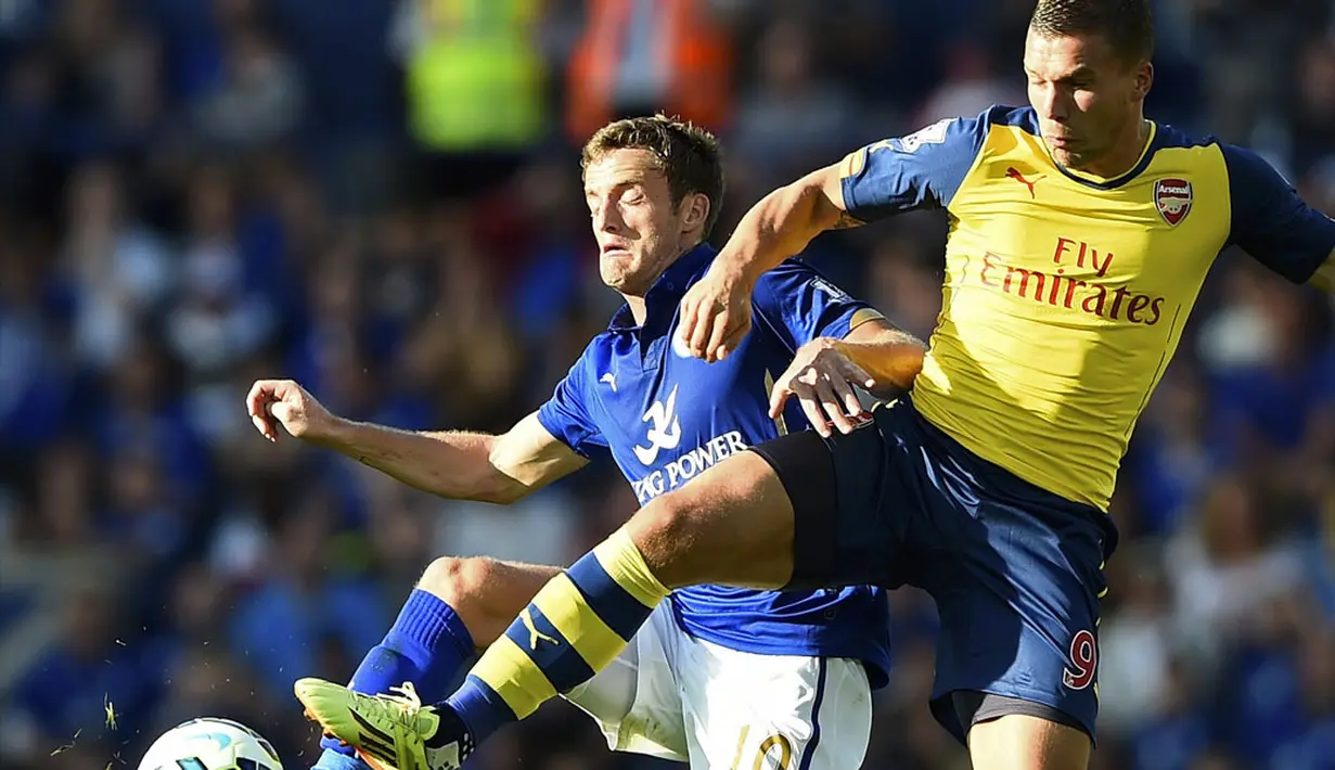 Pemain depan Arsenal, Lukas Podolski (kanan), berebut penguasaan bola dengan gelandang Leicester City, Andy King, saat berlaga di lanjutan Liga Primer Inggris 2014-2015 di Stadion King Power, (31/8/2014). (REUTERS/Dylan Martinez)