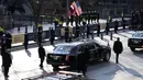 Pengawal mengelilingi mobil Presiden Amerika Serikat (AS), Joe Biden yang menuju Gedung Putih di 15th street, Washington, Rabu (20/1/2020). Joe Biden menggunakan mobil dinas yang sama dengan yang digunakan oleh Presiden sebelumnya, Donald Trump yaitu Cadillac One. (Jose Luis Magana/POOL/AFP)