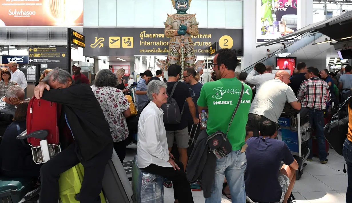 Sejumlah penumpang beristirahat di area check-in di Bandara Internasional Suvarnabhumi di Bangkok (28/2). Hampir Ribuan penumpang tujuan Pakistan dan Eropa terjebak di bandara tersebut. (AFP Photo/Lillian Suwnrumpha)
