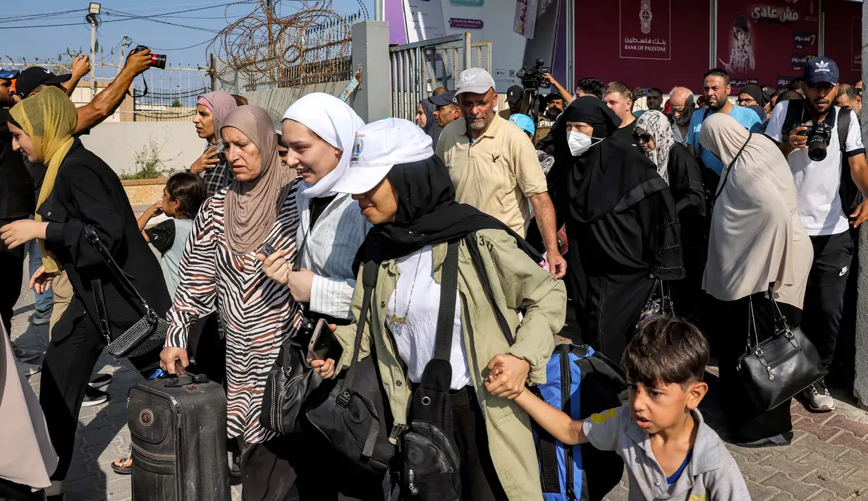 Sejumlah orang dan mobil bergerak dari Gaza melalui gerbang yang dibuka pertama kali pada siang hari. (Mohammed ABED/AFP)