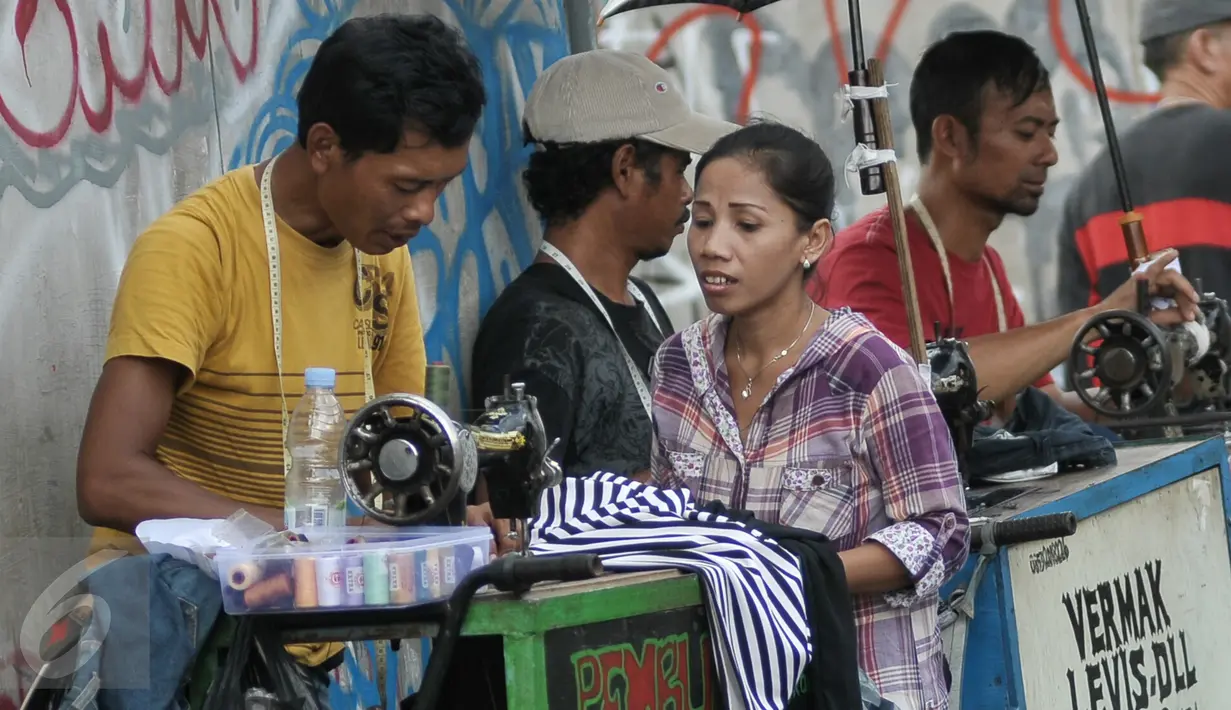 Seorang perempuan menunggu pakaiannya yang sedang dikecilkan oleh penjahit keliling di kawasan Lenteng Agung, Jakarta, Senin (4/7). Menjelang hari raya Idul Fitri, penjahit 'vermak levis' keliling mulai kebanjiran rezeki. (Liputan6.com/Yoppy Renato)