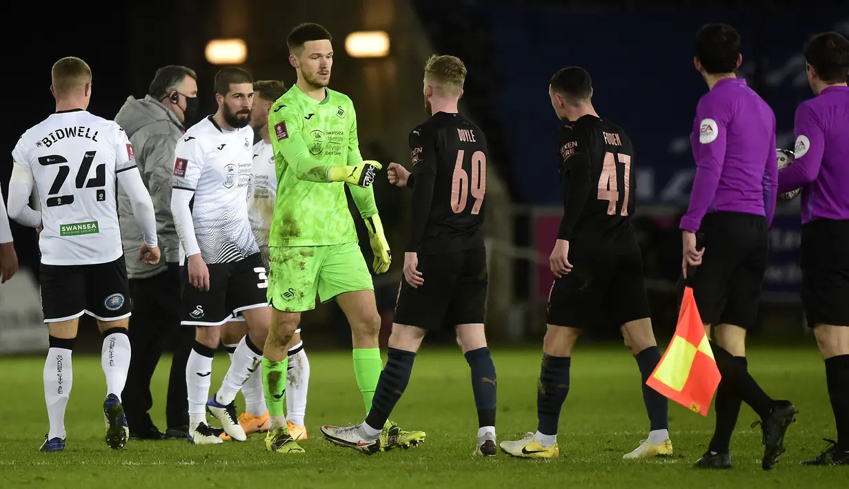 Kiper Swansea City, Freddie Woodman dan gelandang Manchester City Tommy Doyle melakukan pukulan tinju usai pertandingan perdelapan final Piala FA di di Liberty Stadium di Swansea, Wales, Kamis (11/2/2021). Kemenangan ini membuat City lolos ke perempat final Piala FA. (AFP/Pool/Rebbeca Naden)