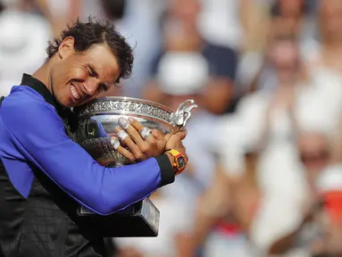 Rafael Nadal memeluk trofi juara usai mengalahkan petenis Swis, Stan Wawrinka  pada laga Final Tunggal Putra, Prancis Terbuka 2017 di Roland Garros stadium, Paris, (11/6/2017). Nadal menang  6-2, 6-3, 6-1. (AP/Christophe Ena)