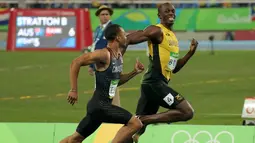 Usain Bolt tersenyum tersenyum dengan Andre de Grasse, pelari Kanada saat bersaing di semifinal lari 200 meter pria di Rio de Janeiro, Brasil (17/8). Usain Bolt meraih medali emas kedua di lari 200 meter pria. (REUTERS/Gonzalo Fuentes)