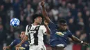 Gelandang Juventus, Juan Cuadrado berebut bola udara dengan gelandang MU, Paul Pogba selama pertandingan grup H Liga Champions di stadion Allianz di Turin, Italia (7/11). Juventus  kalah 2-1 atas MU. (AFP Photo/Miguel Medina)