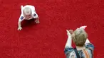 Seorang ibu memberi semangat bayinya yang sedang merangkak saat mengikuti lomba 'Balap Bayi' di Vilnius, Lithuania (1/6). Lomba ini diadakan dalam rangka memperingati Hari Anak Internasional. (REUTERS/Ints Kalnins)