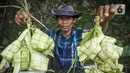 <p>Seorang pedagang menunjukkan kulit ketupat saat menunggu pembeli di Jakarta, Sabtu (30/4/2022). H-2 Lebaran 2022 penjualan kulit ketupat mengalami peningkatan dengan harga jual Rp 6 ribu untuk 10 lembar atau bahan dan Rp 10 ribu untuk harga perikat. (Liputan6.com/Faizal Fanani)</p>