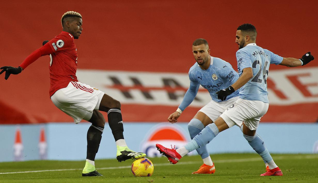 Gelandang Manchester United, Paul Pogba (kiri) dijaga dua pemain Manchester City, Riyad Mahrez (kanan) dan Kyle Walker, dalam laga lanjutan Liga Inggris 2020/21 pekan ke-12 di Old Trafford Stadium, Sabtu (12/12/2020). Manchester United bermain imbang 0-0 dengan Manchester City. (AFP/Phil Noble/Pool)