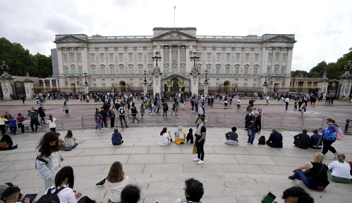 <p>Turis berdiri di depan Istana Buckingham di London, Kamis (8/9/2022). Istana Buckingham mengatakan Ratu Elizabeth II telah ditempatkan di bawah pengawasan medis karena dokter "memperhatikan kesehatan Yang Mulia." Anggota keluarga kerajaan pergi ke Skotlandia untuk bersama raja berusia 96 tahun itu. (AP Photo/Frank Augstein)</p>