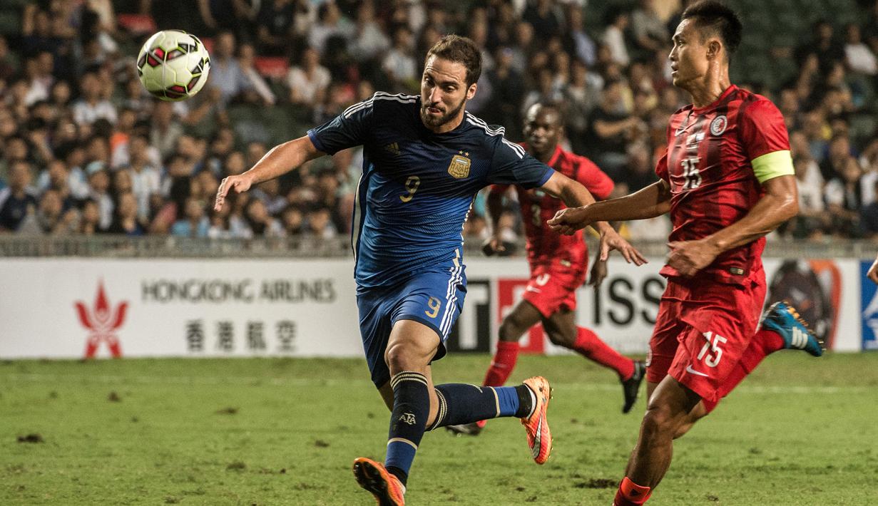 Striker Argentina, Gonzalo Higuain (kiri) menguasai bola dibayangi bek Timnas Hong Kong, Wai Ho Chan pada laga persahabatan internasional di Hong Kong Stadium, Hong Kong (14/10/2014). (AFP/Anthony Wallace)