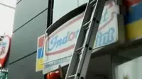 Petugas mencopot papan reklame sebuah minimarket lantaran tidak membayar pajak. 