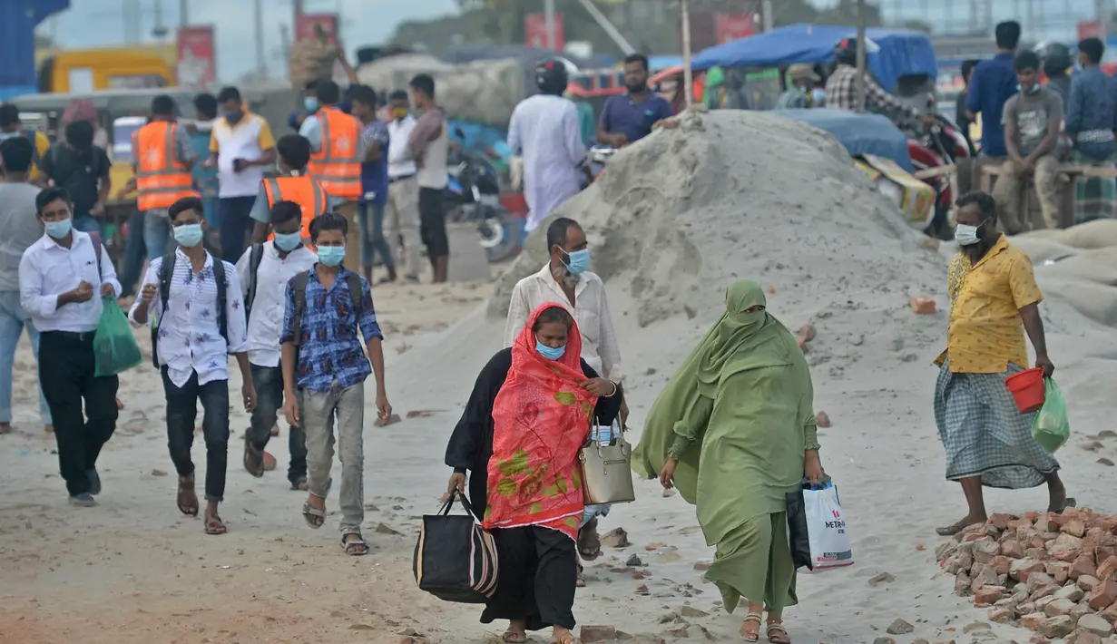 Orang-orang berjalan untuk naik feri menuju kota asal mereka setelah pelonggaran lockdown nasional COVID-19 di Sreenagar, Selasa (13/7/2021). Pemerintah Bangladesh melonggarkan lockdown yang sedang berlangsung selama seminggu mulai 15 hingga 22 Juli untuk perayaan Idul Adha. (Munir Uz zaman/AFP)