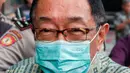 Alim Markus terlihat mengenakan masker berwarna hijau dan bungkam kepada awak media. (Liputan6.com/Angga Yuniar)