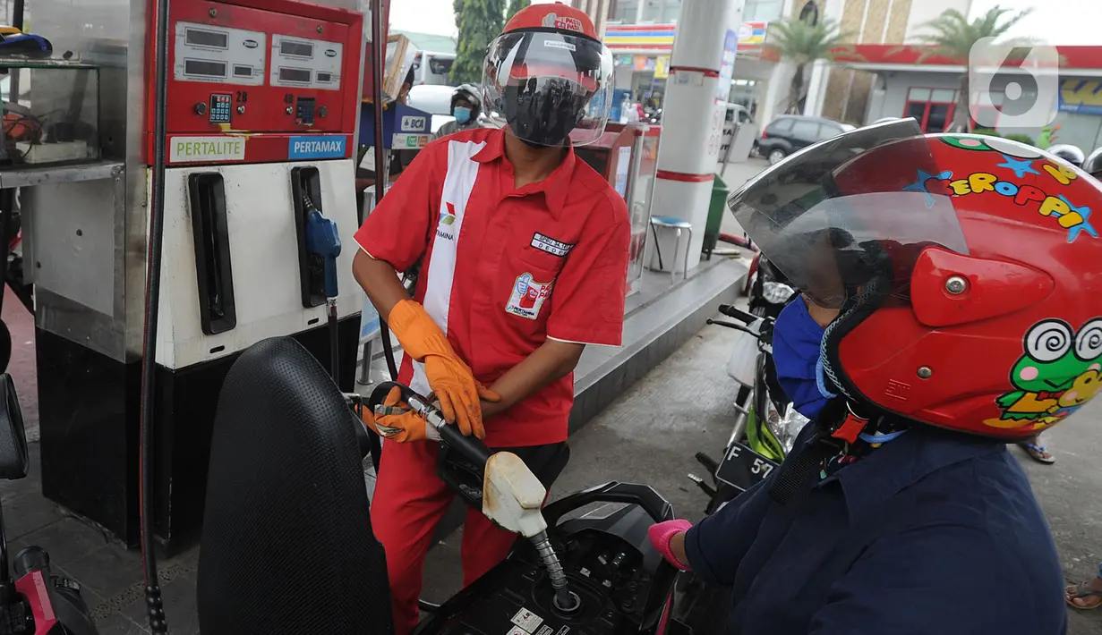 Petugas dengan sarung tangan, masker dan pelindung wajah melayani pembeli BBM di SPBU kawasan Cilendek, Bogor, Selasa (5/5/2020). Mencegah penularan Covid-19, sejumlah perusahaan memberikan pelindung diri kepada pegawai, terlebih yang berhubungan langsung dengan pelanggan. (merdeka.com/Arie Basuki)