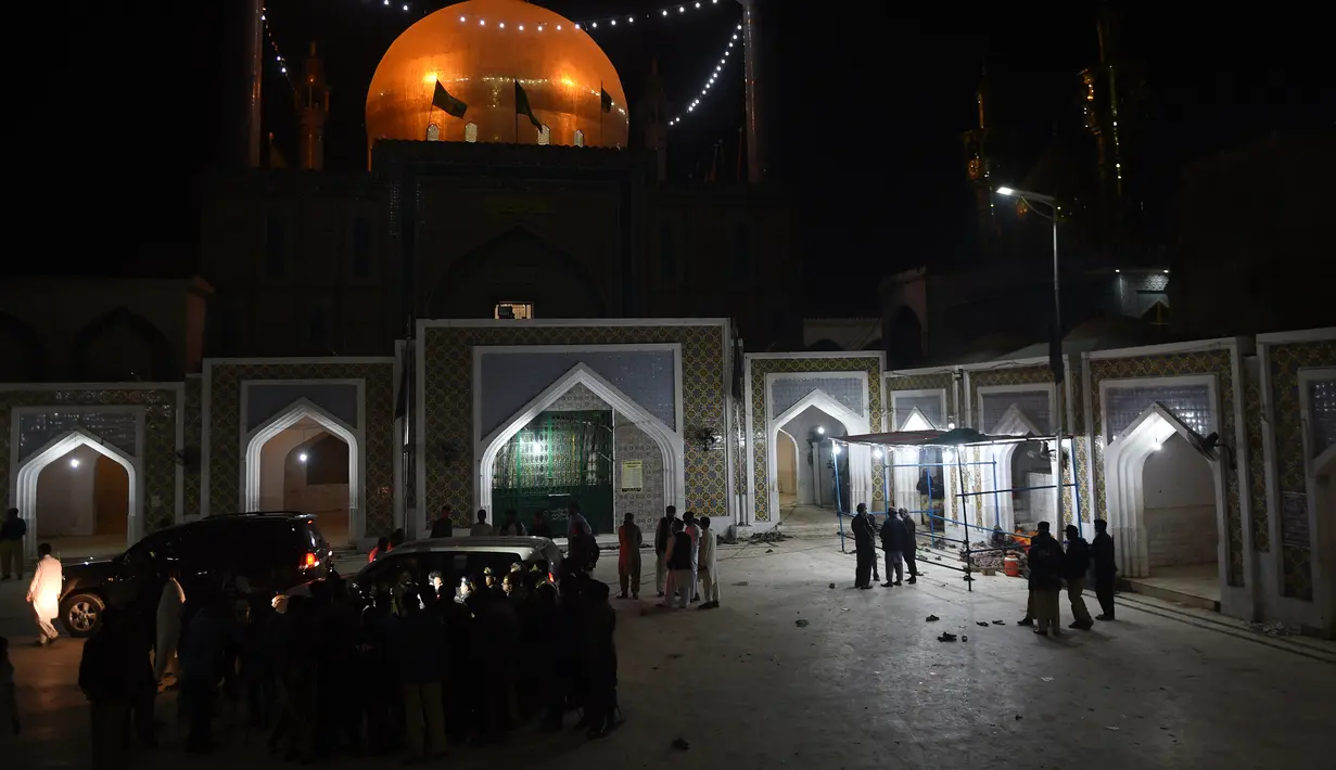Pasukan keamanan bersiaga di depan lokasi serangan bom bunuh diri di tempat suci Lal Shahbaz Qalandar di Provinsi Sindh, Pakistan selatan, Kamis (16/2). ISIS telah mengklaim serangan mematikan tersebut dilakukan oleh kelompoknya. (YOUSUF NAGORI/AFP)