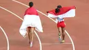 Selebrasi putri Indonesia, Rini Budiarti (kiri) yang meraih medali perak dan Triyaningsih meraih emas nomor lari 5.000m SEA Games 2015. (Bola.com/Arief Bagus)