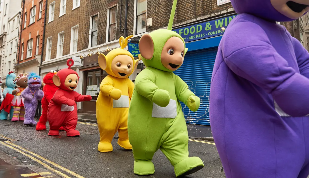 Sejumlah peserta mengenakan kostum karakter tokoh hiburan anak, salah satunya Teletubbies saat mengikuti Hamleys Natal Toy Parade di Regent Street di London, Inggris (20/11). (AFP/Niklas Halle'n)
