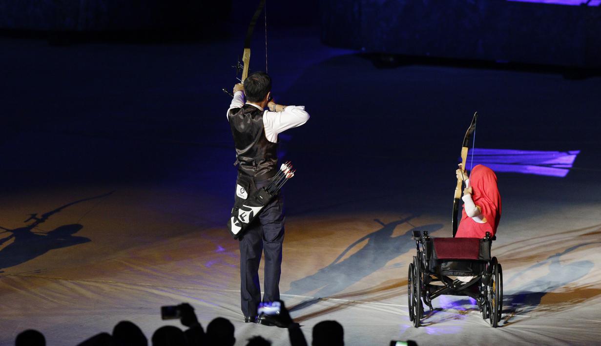 Presiden Indonesia, Joko Widodo, bersama penyandang disabilitas memanah tugu saat pembukaan Asian Para Games di SUGBK, Jakarta, Sabtu (06/10/2018). Acara tersebut dimeriahkan dengan aksi para penyandang disabilitas. (Bola.com/M Iqbal Ichsan)