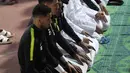 Para pemain Timas Qatar salat berjamaah sebelum sesi latihan mereka di Abu Dhabi (31/1). Qatar harus melewati Korea Selatan sebelum menginjakkan kakinya di final Piala Asia 2019. (AFP Photo/Roslan Rahman)