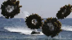 Kendaraan tempur amfibi mengeluarkan bom asap selama latihan militer Korea Selatan dan Amerika Serikat di Pohang , Korea Selatan, (12/3). Latihan tersebut diikuti 300 ribu pasukan Korsel dan sekitar 17 ribu pasukan Amerika. (REUTERS / Kim Hong - Ji)