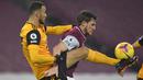 Bek Wolverhampton Wanderers, Romain Saiss (kiri), berebut bola dengan striker Burnley, Chris Wood, dalam laga lanjutan Liga Inggris pekan ke-14 di Turf Moor Stadium, Senin (21/12/2020). Wolverhampton kalah 1-2 dari Burnley. (AFP/Peter Powell/Pool)