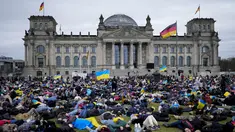 Orang-orang berbaring di tanah melambangkan mereka yang tewas dalam perang di Ukraina selama demonstrasi menentang invasi Rusia, di depan gedung Reichstag di Berlin, Jerman, 6 April 2022. Pengunjuk rasa menuntut Berlin berhenti membeli minyak dan gas Rusia. (AP Photo/Markus Schreiber)