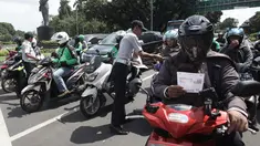 Petugas Dishub DKI Jakarta melakukan sosialisasi lajur khusus sepeda motor di Jalan MH Thamrin, Jakarta, Senin (29/1). (Liputan6.com/Arya Manggala)