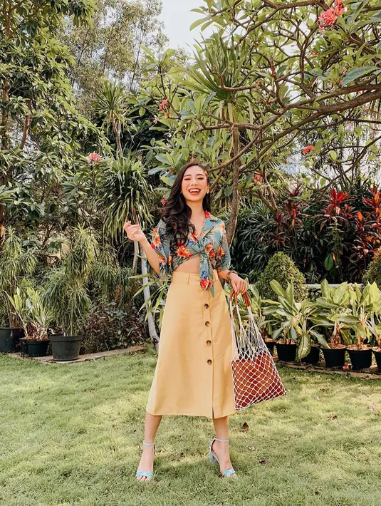 Di foto lain, wanita kelahiran 1995 ini menggunakan atasan bermotif bunga yang dipadukan dengan rok panjang berwarna kuning pastel dan heels warna biru muda. (Liputan6.com/IG/@abellyc)