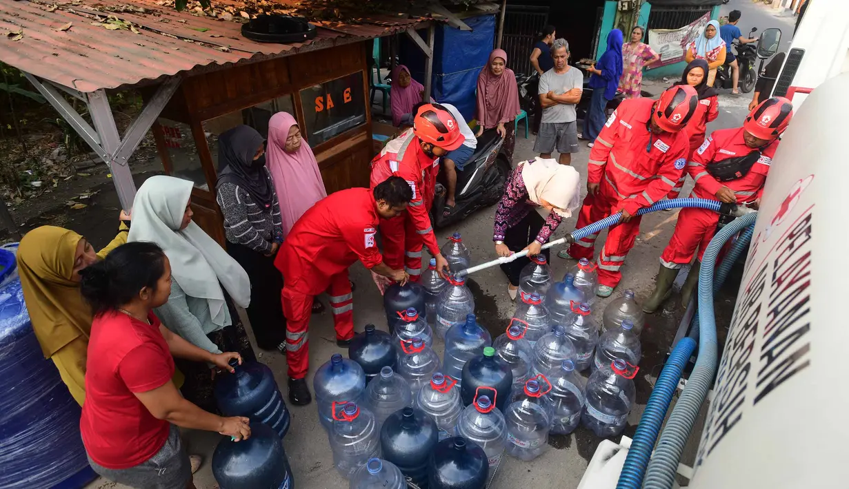 Petugas Palang Merah Indonesia (PMI) mengisi air bersih ke dalam galon air milik warga di RW 08. Cipayung Jaya, Kota Depok, Jawa Barat, Jumat (14/07/2026).