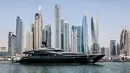 Sebuah kapal pesiar mewah digambarkan di Dubai Marina Beach, emirat Teluk pada 10 Juni 2021. Di tengah aturan pandemi di mana warga harus menjaga jarak dan menghindari keramaian, orang-orang kaya di Dubai memiliki cara untuk bisa pergi berekreasi, yaitu mode wisata kapal pesiar. (Karim SAHIB/AFP)