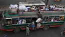 Warga menaiki bus saat mereka melakukan perjalanan ke kampung halaman mereka menjelang perayaan Idul Fitri di Lahore (7/5/2021). Lebaran Idul Fitri jatuh pada 13 Mei 2021. (AFP Photo/Arif Ali)