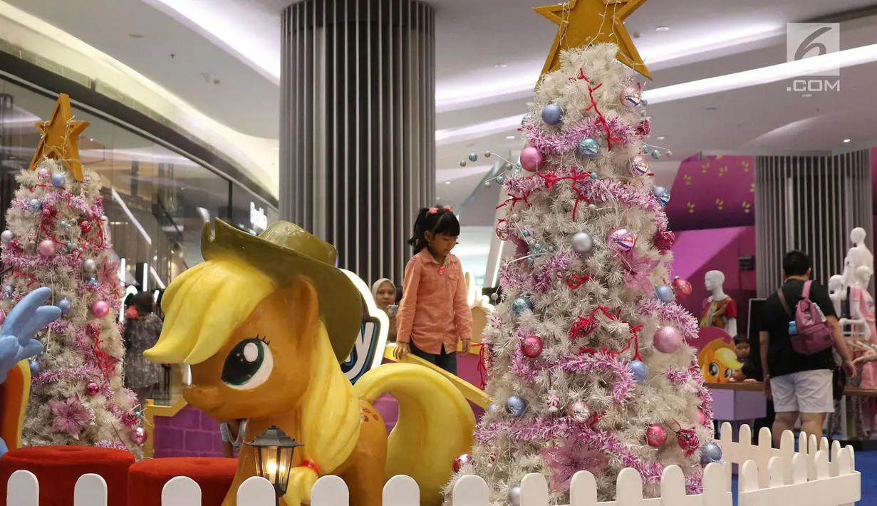 Seorang anak bermain di dekat pohon Natal di Lippo Mal Puri, Jakarta, Jumat (22/12). Jelang Natal banyak pusat perbelanjaan mendekor bangunannya bernuansa natal untuk menarik daya tarik minat masyarakat. (Liputan6.com/Angga yuniar)